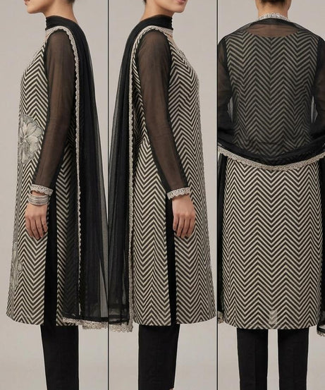 The shirt (kameez) is adorned with a continuous black and cream chevron (zigzag) print, creating a dynamic visual texture that elongates the frame.