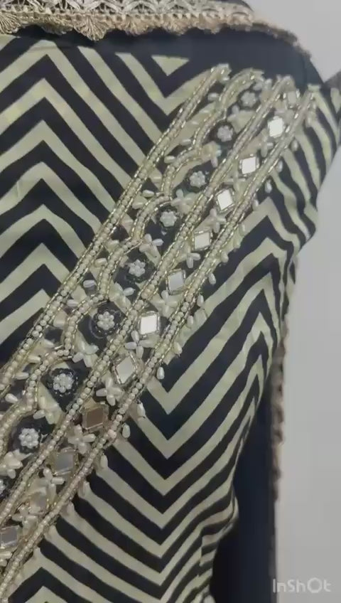 The shirt (kameez) is adorned with a continuous black and cream chevron (zigzag) print, creating a dynamic visual texture that elongates the frame.